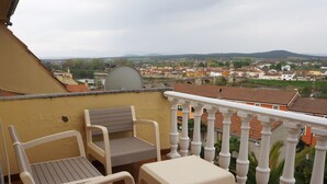 A balcony with two chairs and a table, overlooking a town with houses and a bridge. - House with wonderful views in the heart of Ciudad Rodrigo. " The cherry tree " (Cdad. Rodrigo)
