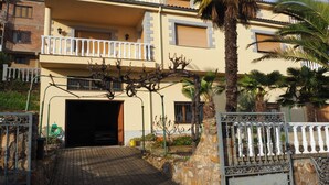 A two-story building with a balcony, a paved entrance, and a gate. - House with wonderful views in the heart of Ciudad Rodrigo. " The cherry tree " (Cdad. Rodrigo)