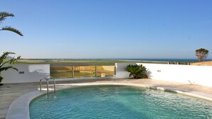 A swimming pool with a view of the ocean and a distant airport. - MARINA 2 - Penthouse Sea-Views - Private terrace. Swimming Pool. Air Cond+Heat (Conil de la Frontera)