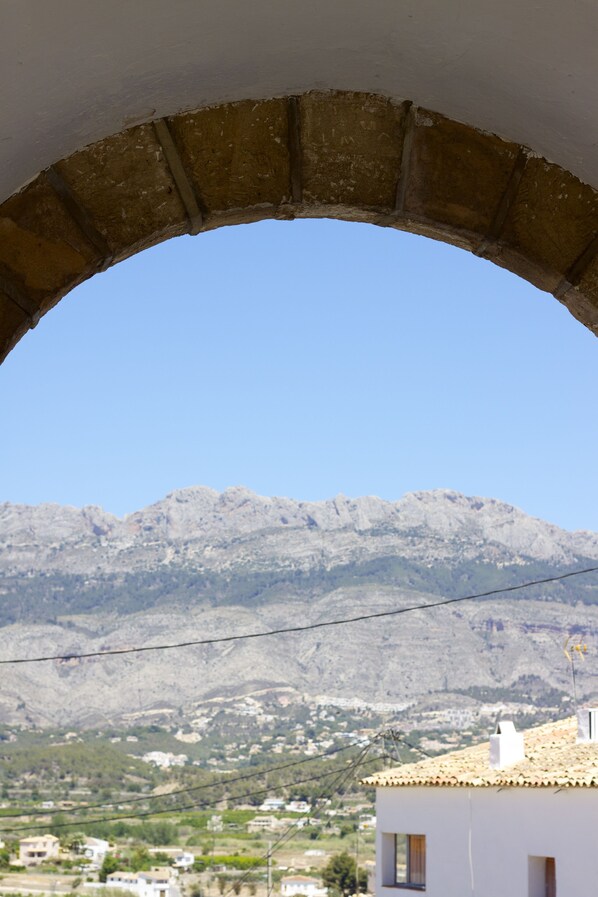 A view through an arched doorway of a building with a mountain in the background. - Modern Apartment In The Heart Of The Old Town (Altea)