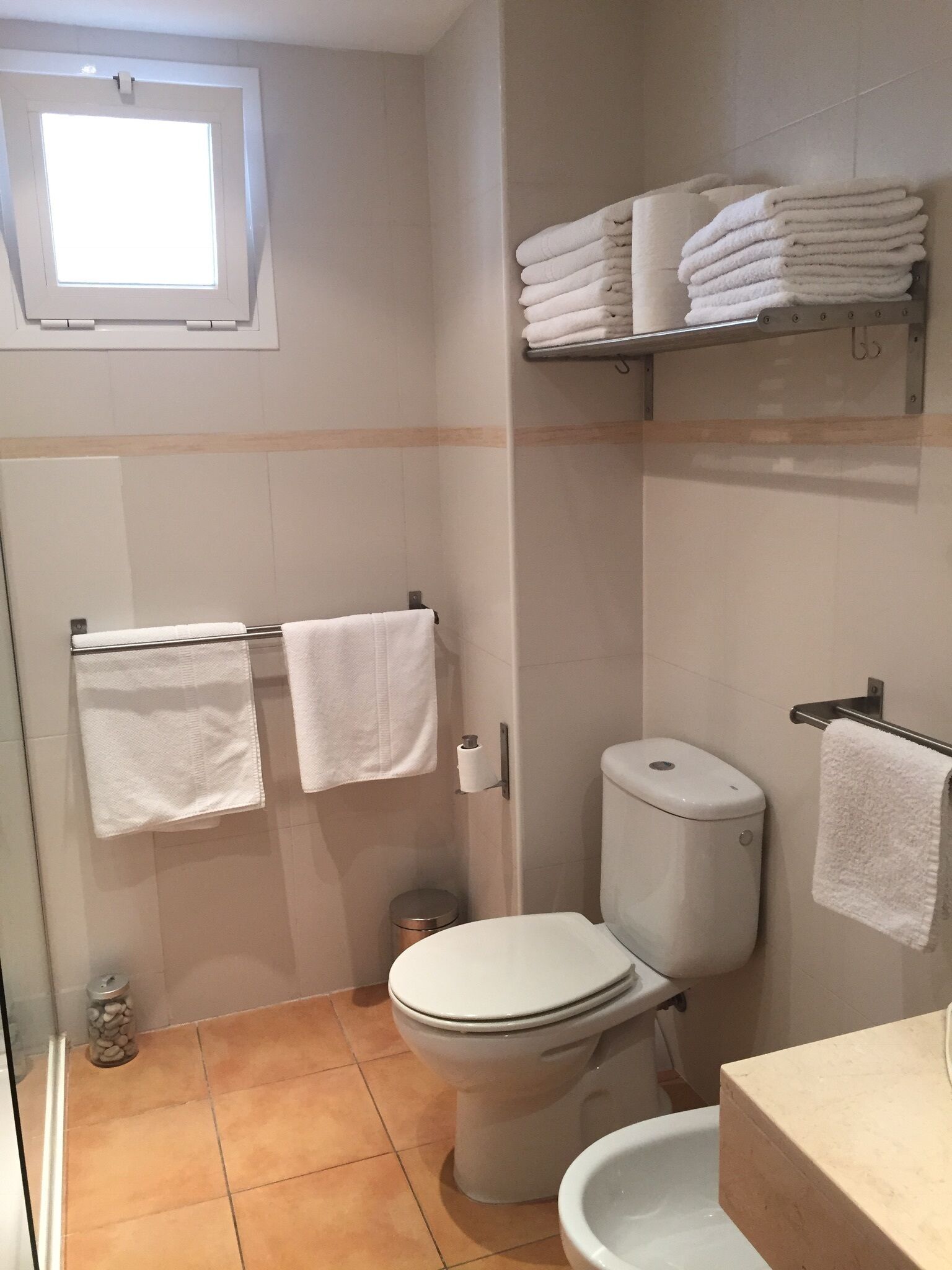 A bathroom with a toilet, sink, and towel rack.