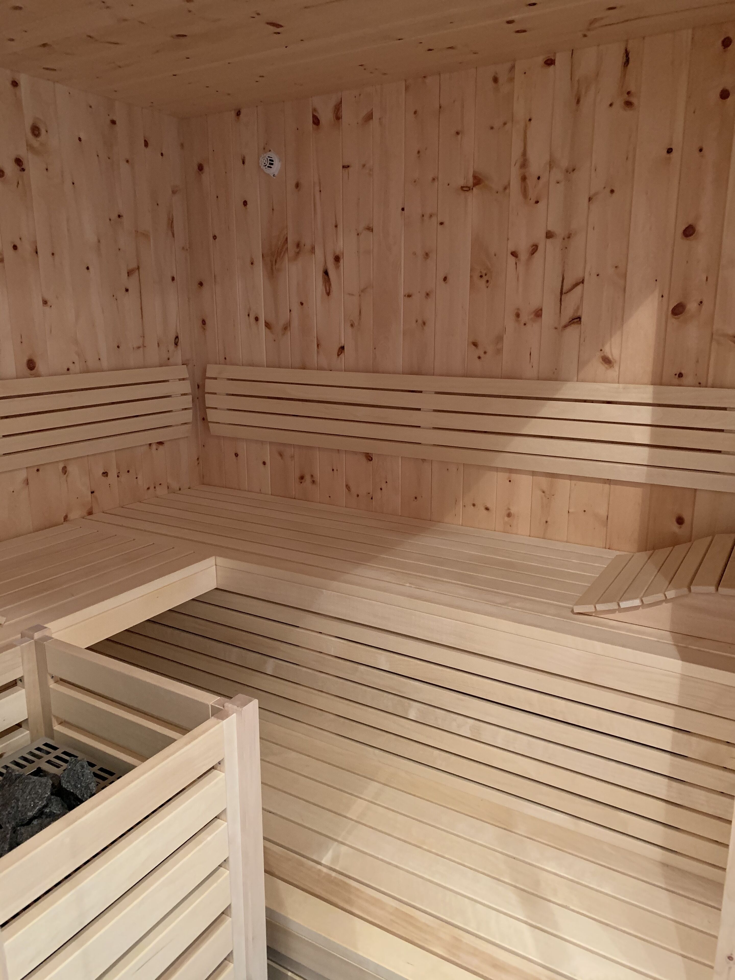 A sauna with wooden benches and a bench with a seat.