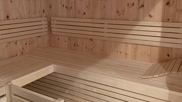 A sauna with wooden benches and a bench with a seat.