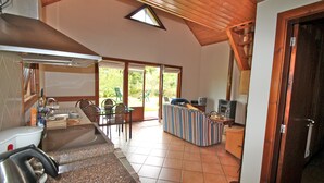 A kitchen with a sink, stove, and a dining area with a sofa and chairs. - Quinta do Pântano is a calm and reserved place, with unique ambience and landscapes (Machico)