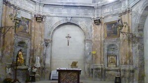 Un intérieur comprenant un autel central, des statues et des décorations murales élaborées.