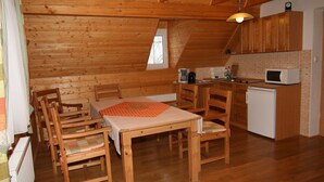 A cozy wooden cabin with a dining area, a small kitchen, and a sleeping area. - 4 lovely apartments on beautiful place in mountains in tourist´s and ski area (Bedrichov)