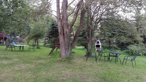 A backyard with a picnic table, chairs, a small tree, and a birdhouse. - 4 lovely apartments on beautiful place in mountains in tourist´s and ski area (Bedrichov)