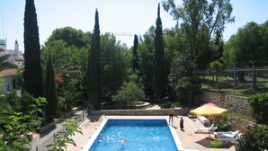 A swimming pool surrounded by trees and a stone wall. - Duplex apartment with communal pool in Cunit (Can Torrents). (Cunit)