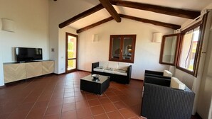 A spacious living area with a television, sofa, and coffee table.