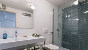 A bathroom with a white sink, a mirror, a glass shower enclosure, and a toilet. - Apartment Mare with beautiful sea views (Lun)