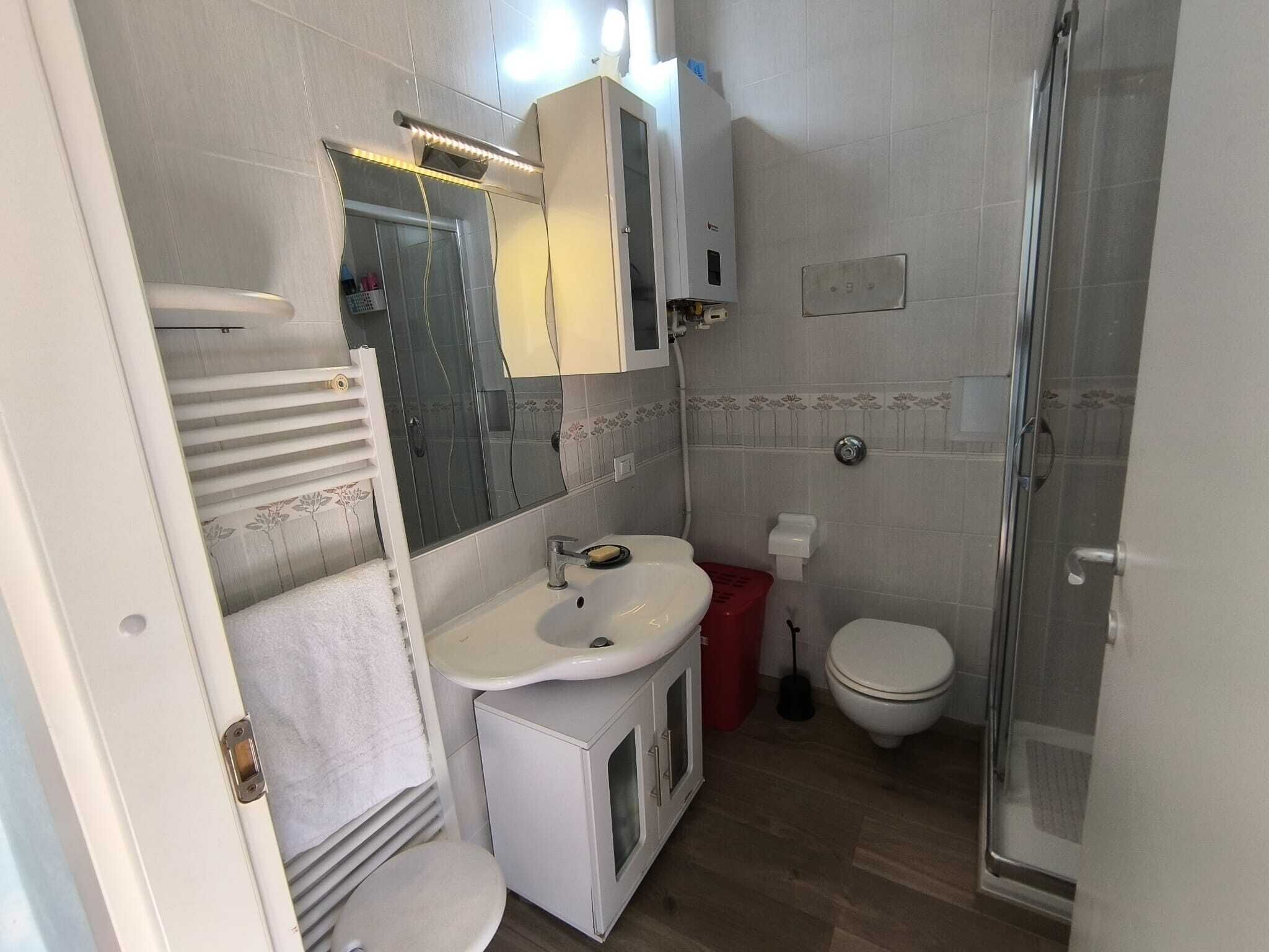 Un baño con lavabo, inodoro, ducha y toallero.