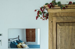 Un dormitorio con cama, almohadas, un tapiz en la pared y cabecera de madera.