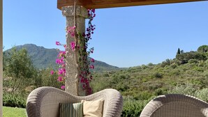 Eine Lounge-Ecke aus Weidengeflecht mit Blick auf eine Berglandschaft.