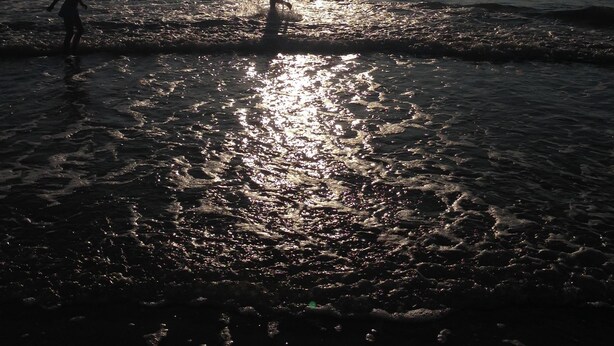 A beach scene with the sun reflecting off the water, creating a shimmering effect. - North Sea vacation right before SPO; 6-8 people, large garden apartment skipper - (Tating)