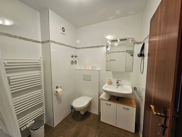Ein modernes Badezimmer mit Dusche, Toilette und Waschbecken.