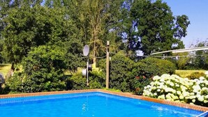 A swimming pool with two metal ladders, surrounded by a brick border and a brick deck. - Apartment in quiet location (Frankenfeld-Bosse)