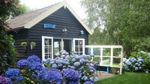 Une petite maison en bois avec une pancarte indiquant « Hortensia Eiland ».