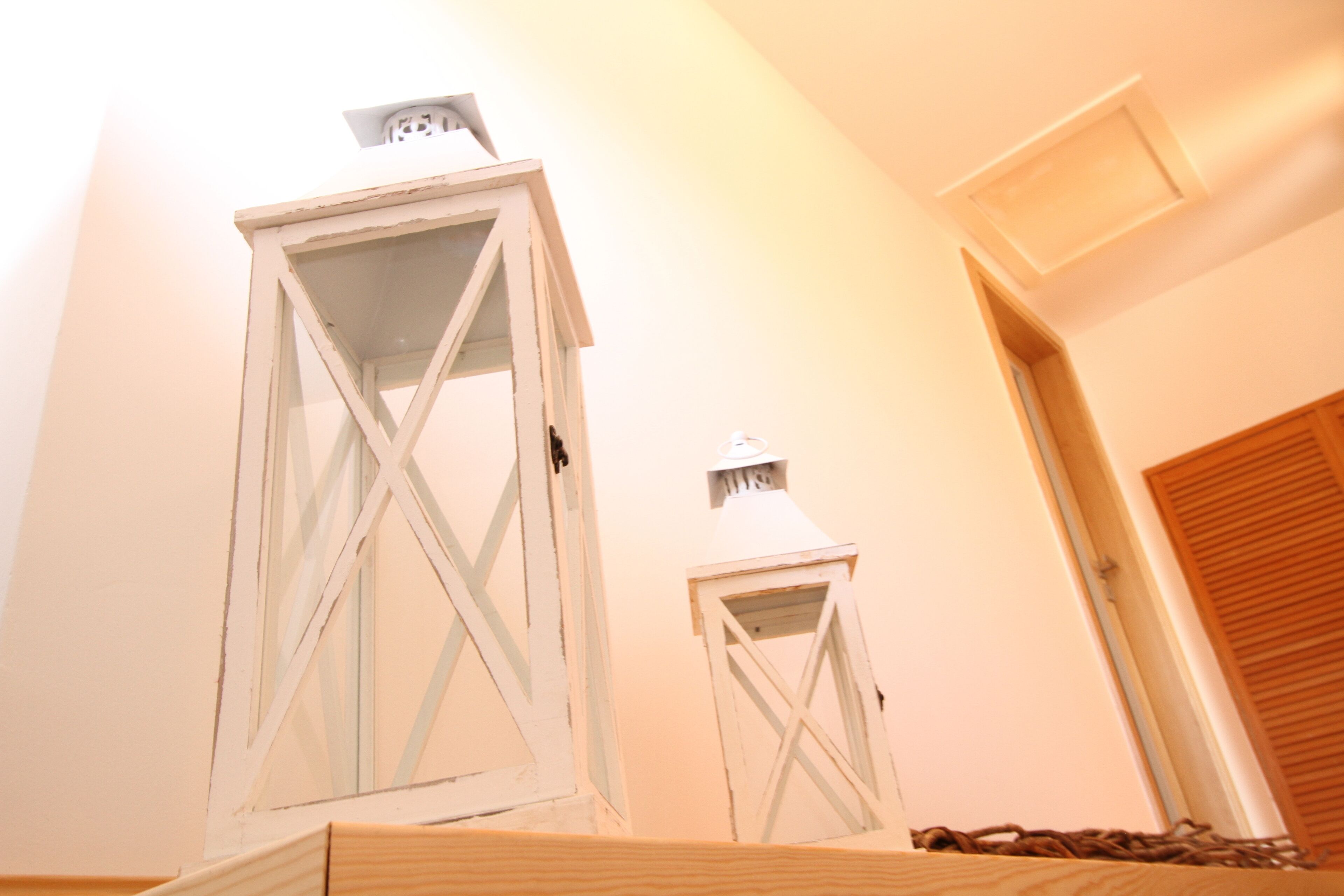 Two white lanterns mounted on a wall.