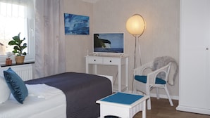 A bedroom with a bed, a desk with a computer, a chair, a lamp, and two paintings on the wall. - Spacious apartment for up to 5 people centrally on the island of Rügen (Bergen auf Rügen OT Ramitz)