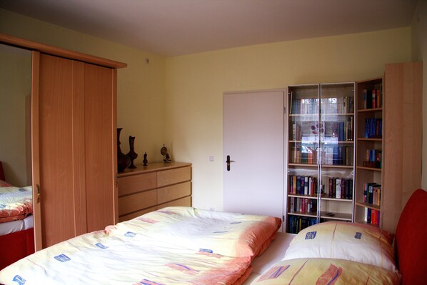 A bedroom with a bed, a wardrobe, a bookshelf, and a door. - Spacious, close to the center and family friendly apartment in Dresden! (Dresden)