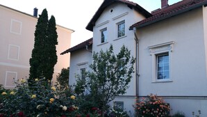 A residential building with a garden featuring roses and a tree. - Spacious, close to the center and family friendly apartment in Dresden! (Dresden)