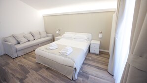 A bedroom with a bed, a sofa, and a nightstand. - DOMUS DAMS BED AND BREAKFAST - Room 11 (Montescaglioso)