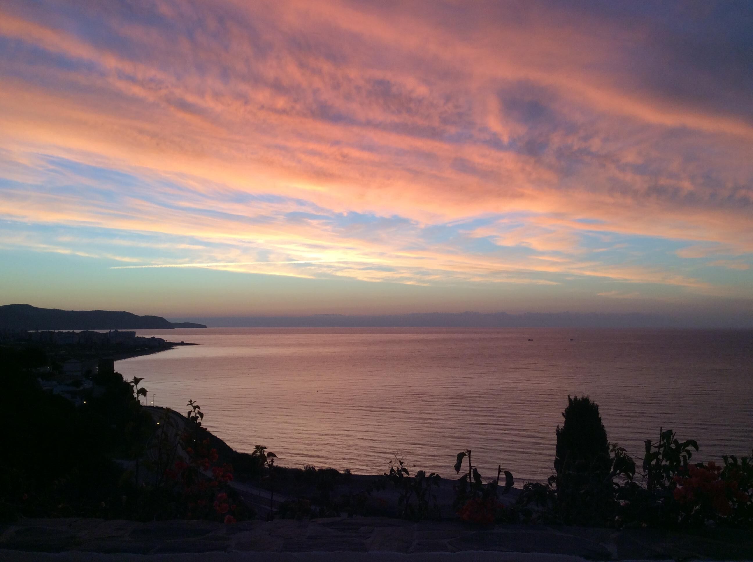 A coastal landscape with a view of the sea and distant hills.