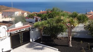 Ein Küstenwohngebiet mit Häusern, einem Tor und Blick auf das Meer.