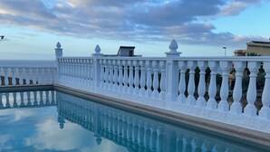 Ein Pool mit weißer Brüstung und freiem Blick zum Himmel.