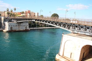 Un pont enjambant une étendue d’eau, avec une vue sur la ville en arrière-plan.