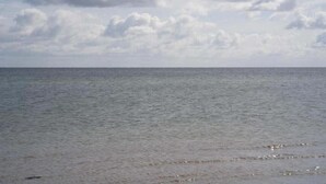 Un mar tranquilo bajo un cielo nublado.