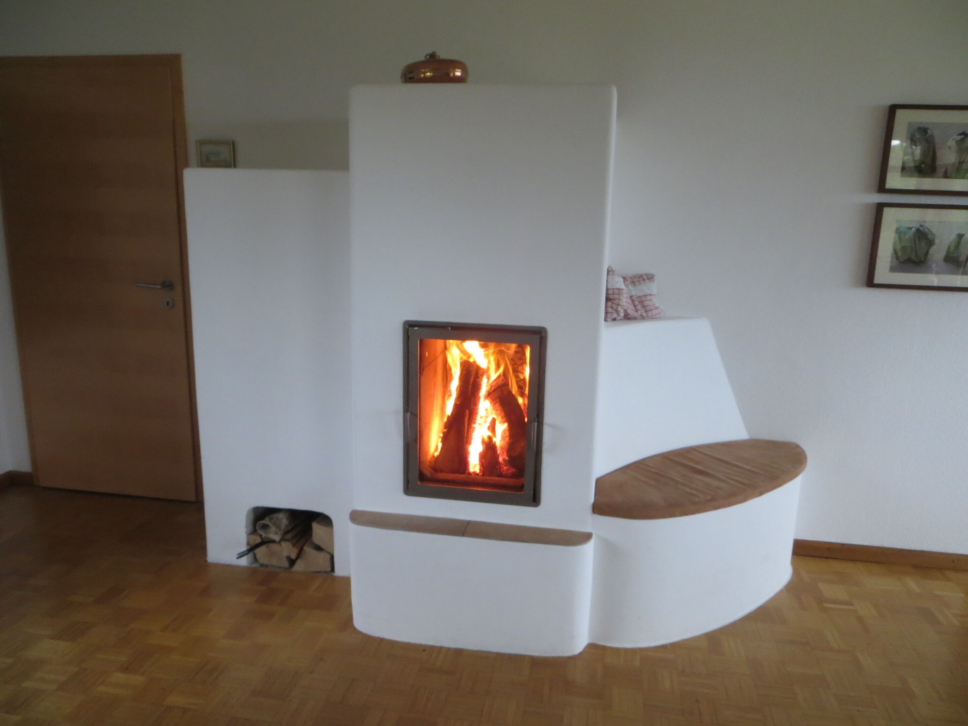 Ein modernes Wohnzimmer mit eingebautem Kamin, einer Holztür und einem gerahmten Bild an der Wand.