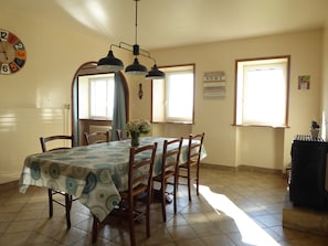 A dining area with a table set for four, a clock on the wall, and a 'Welcome Home' sign. - Independent, very comfortable quiet house near lake and forest (Saint-Jeure-D'andaure)