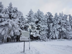Paesaggio innevato con un segnale direzionale che indica diverse destinazioni.