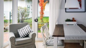 A cozy room with a checkered sofa and a dining table with a checkered tablecloth.