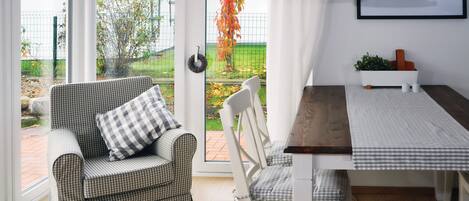 A cozy room with a checkered sofa and a dining table with a checkered tablecloth.