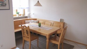 Ein Holztisch mit Stühlen, einer Bank und einem Teppich.