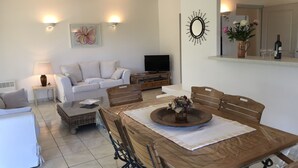 A living room with a sofa, TV, dining table, and chairs. - Pleasant villa seaside with private pool garden 2000m2 (SOLARO)