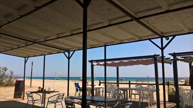A beachside restaurant with outdoor seating, a covered area, and a view of the beach and ocean. - Pleasant villa seaside with private pool garden 2000m2 (SOLARO)
