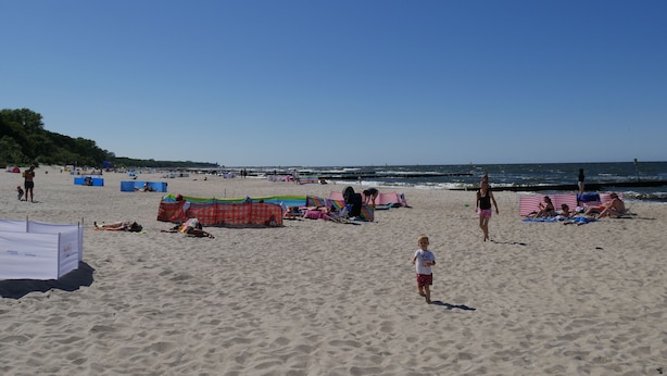 A beach with people relaxing on towels and chairs, some tents set up, and a clear sky. - Beautiful vacation home on the Baltic Sea coast (Zachodnio Pomorskie Baltic Sea coast)
