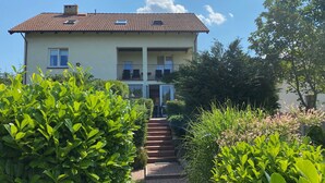 A two-story building with a tiled roof, a balcony on the second floor, and a staircase leading to the entrance. - Beautiful vacation home on the Baltic Sea coast (Zachodnio Pomorskie Baltic Sea coast)
