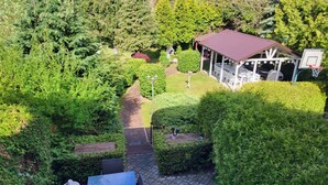A garden with a gazebo, a basketball hoop, and a paved pathway. - Beautiful vacation home on the Baltic Sea coast (Zachodnio Pomorskie Baltic Sea coast)