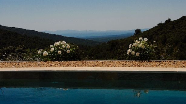 Ein Pool mit freiem Blick auf eine gebirgige Landschaft im Hintergrund.