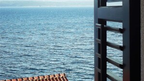 A view of the sea through a window with a metal railing. - The apartment is located on the first floor of our house, 50 meters from the sea (Bol)