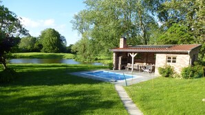 Una casa con piscina, terraza y jardín.