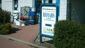 Un bâtiment portant une enseigne indiquant « BIOMARIS » et « FeWo Vermittlung ».