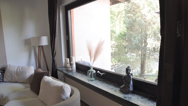 A room with a large window, a sofa, a lamp, and a statue on the windowsill. - MESSE + Airport Nuremberg - Fürth - Erlangen - Bamberg - Rest Nature - Time out (Lauf an der Pegnitz)