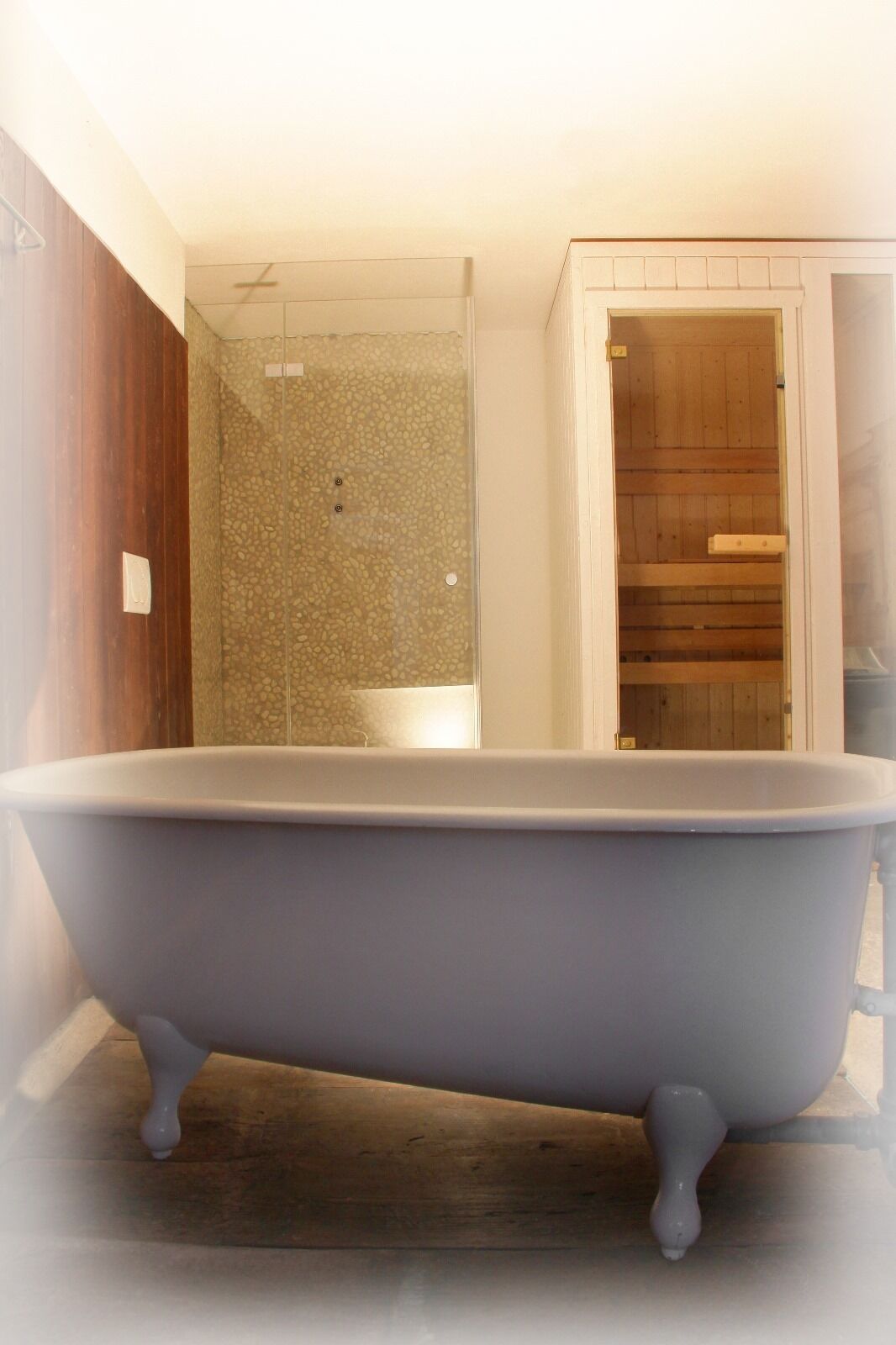 Un baño con una bañera independiente, zona de ducha y un armario de madera.