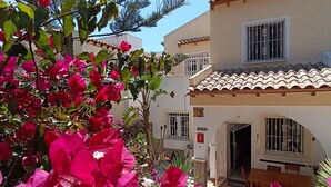 A building with a tiled roof, a balcony, and a door leading to an interior space. - Top renovated holiday home with AC, Wi-Fi, satellite, infrared heating (Villamartin)