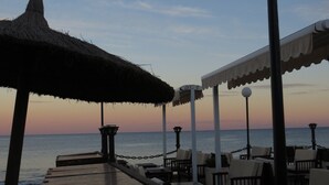 A beachside restaurant with outdoor seating, thatched umbrellas, and a view of the sea. - Top renovated holiday home with AC, Wi-Fi, satellite, infrared heating (Villamartin)